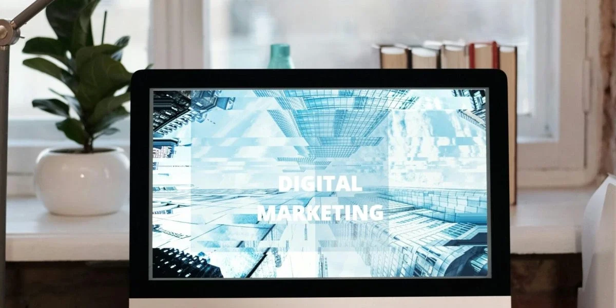 digital-marketing-strategy-services It displays a sleek laptop screen in the foreground, showcasing a vibrant graphic with the text "DIGITAL MARKETING" prominently displayed, highlighting a core service area.